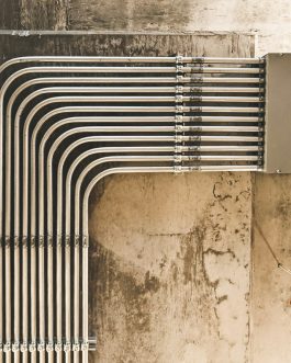 grey metal pipe on brown concrete wall